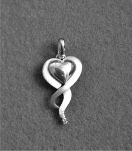 Zilveren, hartvormige hanger waarin de as van een dierbare overledene is verwerkt.