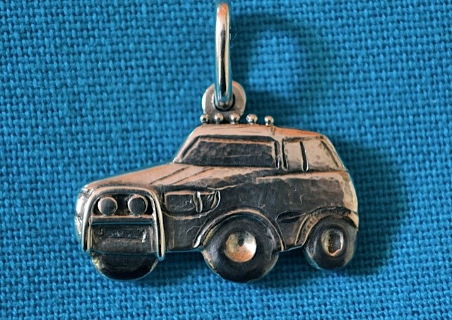 assieraad                           Zilveren hanger in de vorm van een auto waarin de as is verwerkt van een dierbare overledene.