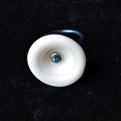 Ring Bali. Ring van titanium met schelp waarin een blauwe topaz is gezet.